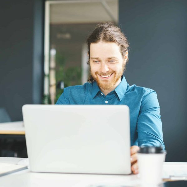 happy-young-male-office-employee-working-on-laptop-computer.jpg